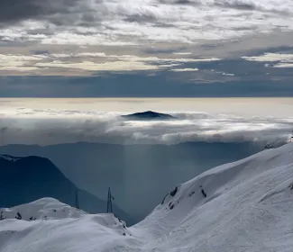 snow covered mountain under cloudy sky during daytime by Mihály Köles courtesy of Unsplash.